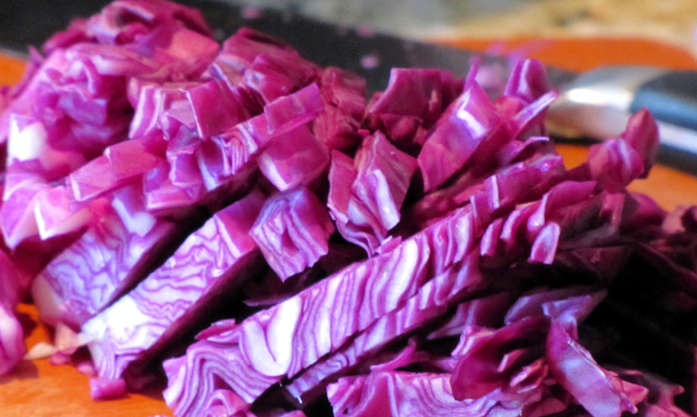 Red Acre cabbage seeds from SeedsNow, showing vibrant red cabbage seeds on a white background for planting and gardening.